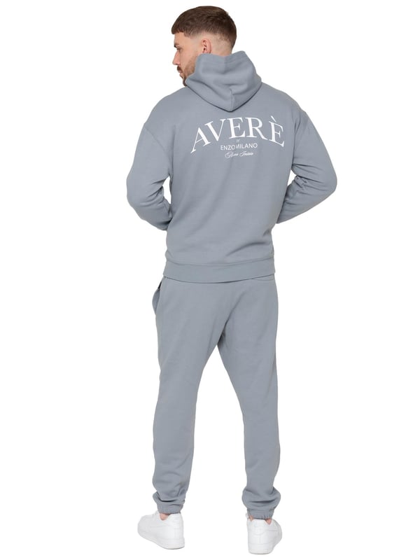 Presentamos el Conjunto de Chándal con Sudadera con Capucha Oversized Averè para Hombre de Enzo Milano, una mezcla perfecta de comodidad y estilo. Este set incluye una Sudadera con Capucha Oversized con un suave forro de felpa, un logotipo sutil en el pecho, un diseño audaz en la parte trasera y una capucha con botones a presión. Los Joggers de Corte Regular tienen una cintura elástica, cordones ajustables, bolsillos laterales y puños acanalados en los tobillos para un ajuste seguro. Ideal para relajarse o para salidas casuales, este chándal ofrece un estilo relajado y a la moda