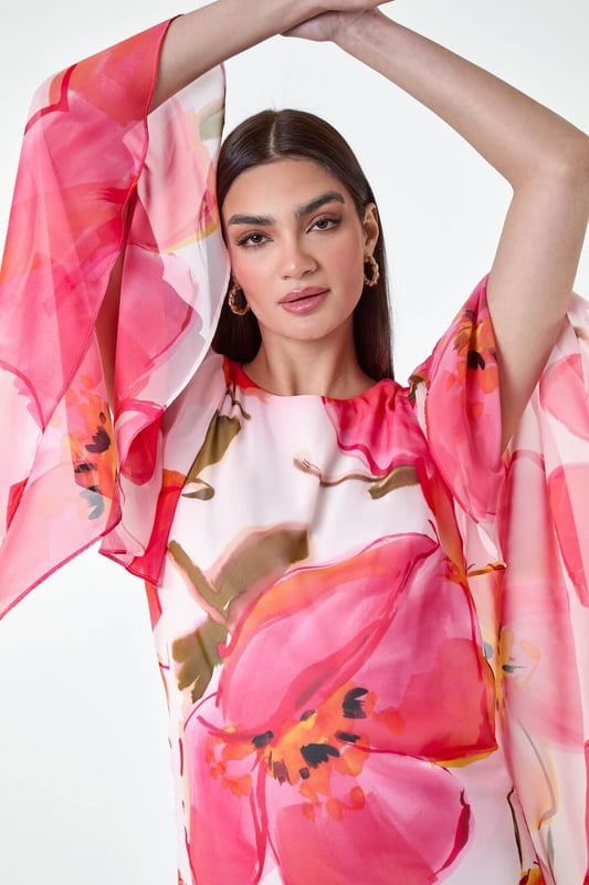 Floral Print Chiffon Cape Shift Dress from Roman. Make a statement this season in our elegant, Ariella collection chiffon cape dress. This stunning piece is perfect for those special events with its modest round neckline and secure zip fastening. The whimsical cape sleeves add a touch of drama to the classic shift shape, while the beautiful floral print exudes femininity. The draped chiffon fabric floats gracefully as you move, making you feel like a true belle of the ball! Whether you're attending a wedding or a formal dinner, style with strappy heels and a clutch bag for a look that's sure to turn heads!