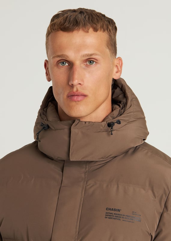 Material & Fit The Nebula is a short winter jacket. This puffer jacket is fully made of polyester, making it very lightweight. Additionally, it is water-repellent, windproof, and breathable.  Details This puffer jacket features a detachable hood and adjustable sleeve openings. The Nebula has a total of 3 pockets, including 2 hidden side pockets and one inside pocket, all with zip closures. Furthermore, the winter jacket is equipped with a plastic zipper and signature CHASIN’ details.  Performance Features  Breathable Keep warm Quick dry Water repellant Wind proof Specs  Detachable hood 3 pockets Plastic zipper Lightweight material CHASIN' details Model is wearing size L and is 1.89 m tall. His waist measures 74 cm and his chest measures 90 cm.