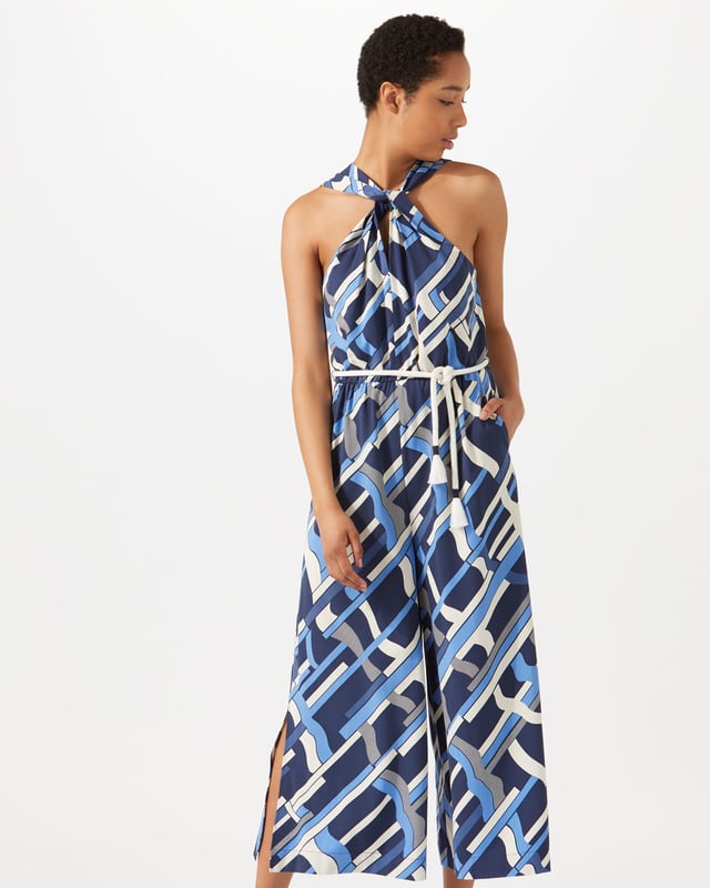 This jumpsuit features an exclusive modern Jigsaw print, hand-drawn by our in-house artist as a modern take on a check. Styled with a wide leg, it has a twist design at the neck and a rope tie at waist for a playful finish. Pair with heels for summer evenings out.