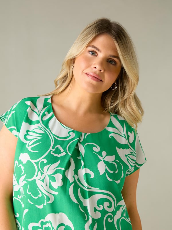 Printed all over with a pretty green paisley print, this top is cut from a lightweight woven fabric thats so comfortable. With a flattering V-neckline with a pleat, it has short sleeves for coverage, making this the perfect throw-on warm weather piece.