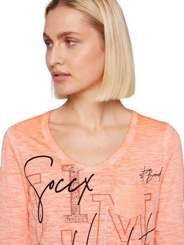 Dit damesshirt met lange mouwen is op vele manieren te combineren en is een musthave basic voor jouw garderobe. Het heeft een losse pasvorm en is gemaakt van hoogwaardig materiaal. Het shirt heeft een V-hals die is omzoomd met een geribbelde bies. De zoom is voorzien van een strikband, waardoor de breedte eenvoudig kan worden aangepast. De slubgarenstructuur zorgt voor een geweldig kleureffect. De grote print op de voorkant wordt geaccentueerd met glitterelementen en geeft het shirt een geweldig visueel hoogtepunt. Een kleine borstzak maakt het ontwerp compleet.