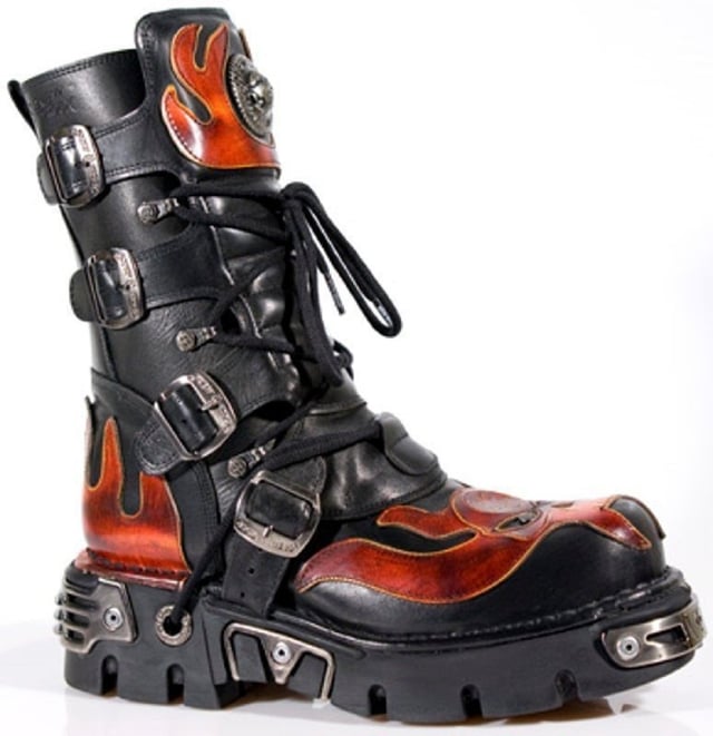 These mid-calf boots are crafted from premium cow hide leather and are finished with a quality that reflects the decades of experience in crafting premium footwear that New Rock has proudly amassed. This pair is characterised by a bold skull art piece and flame design that appears in red on the black leather upper for a striking unique look that is sure to stand you out from the crowd. Another addition to the shoes distinctive look is a metallic motif that is created by the introduction of metal buckles, metallic inserts in the soles and an elegantly designed shiny New Rock logo. Not only is this a stunningly trendy piece but with the addition of a soft cushioned insole, comfortable leather lining and side zip opening these boots reach a level of comfort that will make you want to keep these mid-calves on all day.• Premium black leather uppers with red skull feature• 23cm shaft height with side zip and metal buckles• 6cm rubber heel and 3cm sole