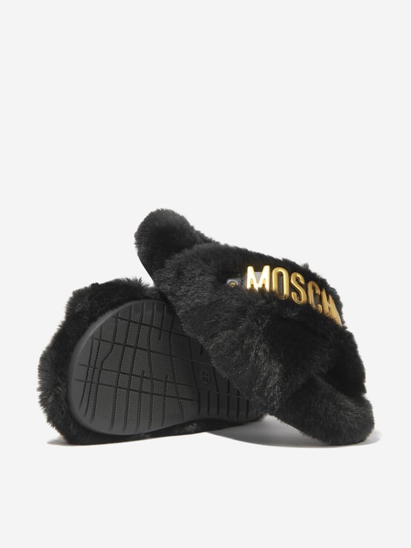 These Moschino Kids Girls Faux Fur Slippers add a touch of luxury to any wardrobe. Crafted from a soft blend of 88% Polyester and 12% Calf Leather, they feature a classic black hue, a furry surface and the iconic logo on the sides. Perfect for casual and formal occasions.·  Moschino Kids·  Made in Italy·  Occasion: Casual·  Print