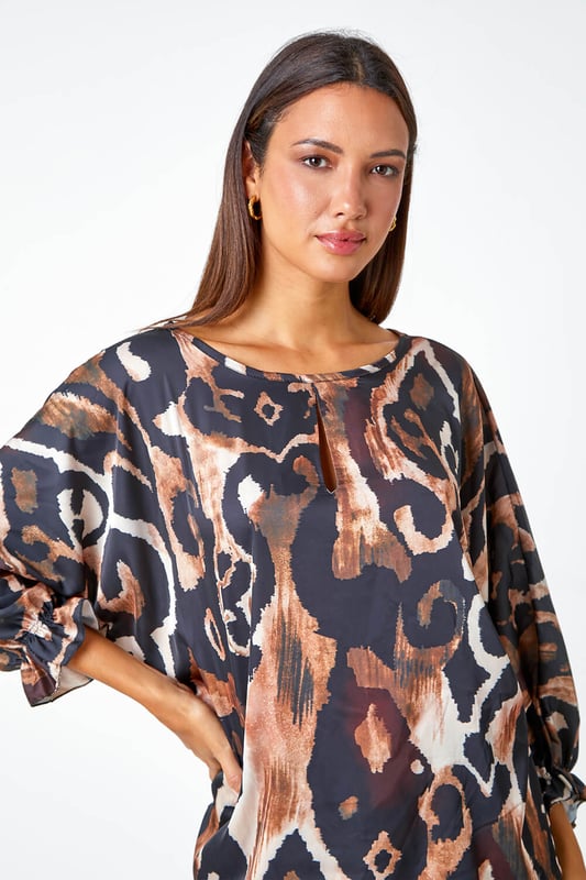 Abstract Print Blouson Sleeve Top from Roman. Elevate your casual collection this season with this luxurious woven top. Bringing a glamorous energy to your daytime style, this top is adorned in an abstract print that's filled with Autumnal hues making it perfect for the upcoming season. Designed with a round neckline which features a playful keyhole cut-out and full-length blouson sleeves that ooze feminine energy. Wear with smart trousers and heels for the perfect desk-to-dinner style.