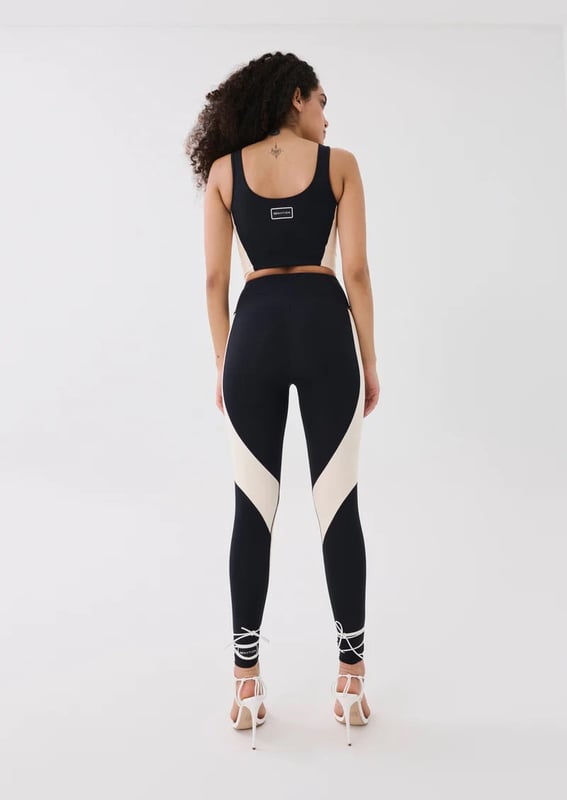 A high-rise full length legging cut in a soft compressive matte blend of recycled nylon and elastane. With built in waistband support, this style is ideal for low impact training and your street-sport wardrobe. A contrast beige curved panel detailing throughout and a P.E Nation silicon badge at the ankle for a minimal finish.