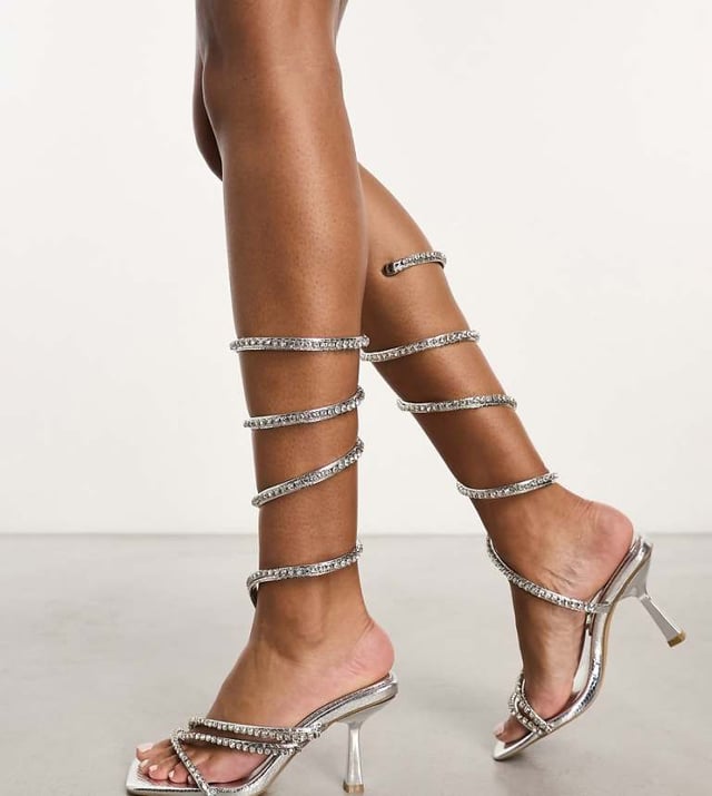 Simmi London Wide fit Freesia embellished leg wrap sandals in silver Shoes by Simmi Wide Fit Dress from the feet up Wrap-around design Diamante embellishment Open toe Flared heelSold By: Asos