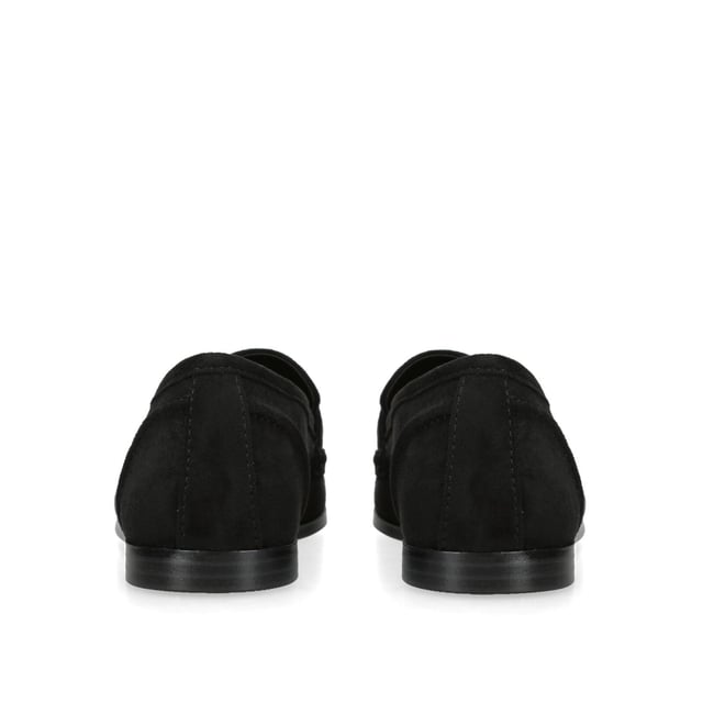 The KG Kurt Geiger Madeline is a black microsuede slip on loafer. There is an antiqued brass horse bit chain across the toe and small KG Kurt Geiger stud.