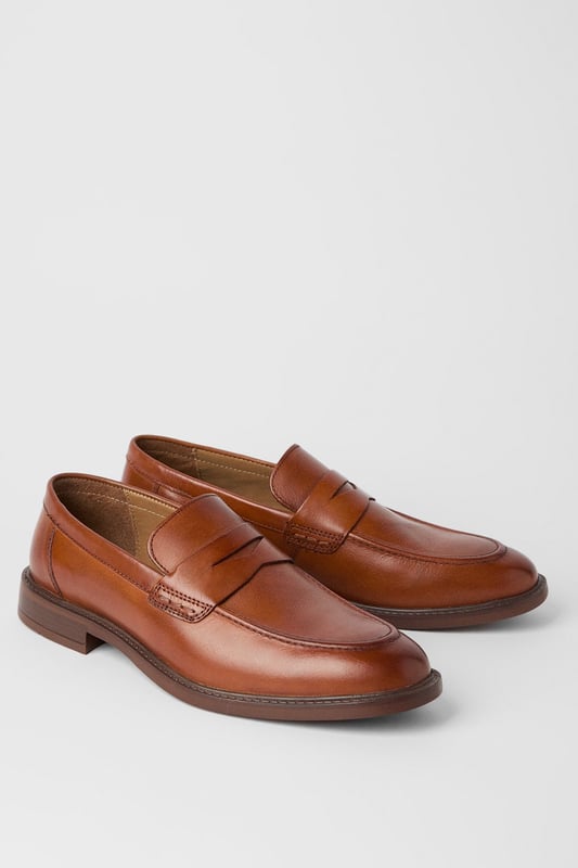 Classic penny loafer design with a modern twist
        Smooth leather upper for a polished appearance
        Slip-on style for easy wear
        Sturdy sole with a slight heel for comfort
        Versatile tan colour suitable for various outfits
    
    Step into sophistication with these smart penny loafers from Maine. The timeless design is given a contemporary update, perfect for the modern gentleman who appreciates classic style. These versatile shoes effortlessly bridge the gap between smart and casual, making them an ideal choice for a range of occasions. Pair them with tailored trousers and a crisp shirt for a refined office look, or dress them down with chinos and a polo shirt for smart-casual events. The slip-on style ensures convenience, while the durable sole provides all-day comfort. Whether you're attending a business meeting or enjoying a weekend brunch, these loafers will add a touch of elegance to your ensemble. Their ability to complement both formal and relaxed attire makes them a must-have addition to any discerning wardrobe.