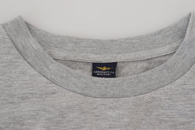 Merk: AERONAUTICA MILITARE  
Staat: Helemaal nieuw met labels  
Stijl: Pullovertrui  
Kleur: Grijs  
Logo-details  
Gemaakt in Italië  
Materiaal: 62% Katoen 32% Polyester 6% Elastaan  
Geslacht: Heren  
Materiaal: 62% Katoen 32% Polyester 6% Elastaan