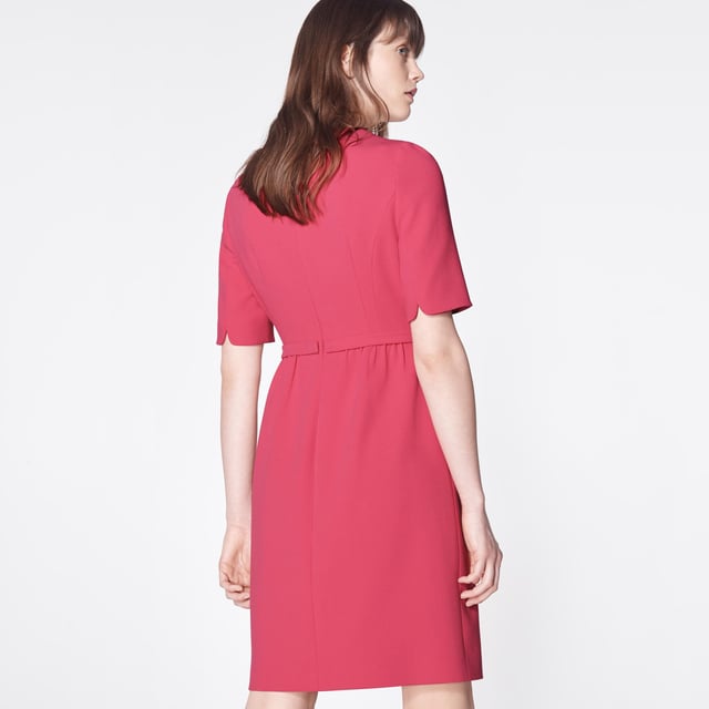 The perfect pink shift, our Elina dress takes its cues from bespoke occasion dresses of an era gone by. Crafted from raspberry pink crepe, it has a round neck, short sleeves, a neat bow belt at the waist and a front panel to the knee-length skirt. Simple and chic, wear it with strappy heels or sleek courts for during the occasion season.