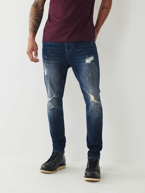 Meet our ultra-slim Jack Jean. This distressed men's super skinny jean features fading, 3D whiskering, and ripped destruction. Finished with two tone stitching, 1/2" horseshoe detailing along the back pockets, and a shorter 30" inseam.