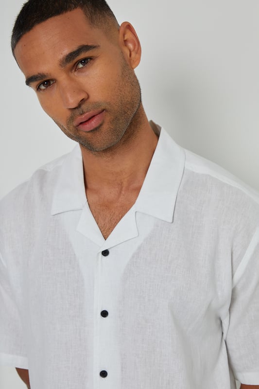 This lightweight shirt from Threadbare will have you ready for the summer months. Crafted from a cool linen blend fabric, this regular fit shirt features a revere collar with single needle stitching and a button-through fastening. The short sleeves and side split vents offer comfort and breathability. Complete with a back yoke seam for added detail, this shirt is perfect for casual outings or beachside gatherings. Pair it with tailored shorts or lightweight trousers for a relaxed look.