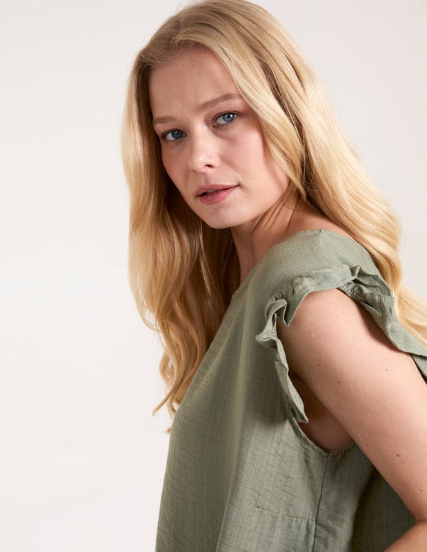 Go for comfort this summer with this Button Back Frill Shoulder Top. Pair with jeans, strappy heels and a headband for an easy day to night look!