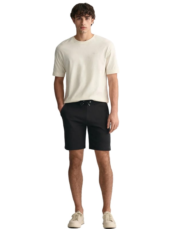 These classic sweat shorts are crafted from a soft cotton blend and tailored for a regular fit. Featuring a ribbed waistband for enhanced comfort, the design includes two front pockets, a single back pocket, and a drawstring waist. Completing the look, the shorts are adorned with a small-scale shield graphic embroidered on the left leg.