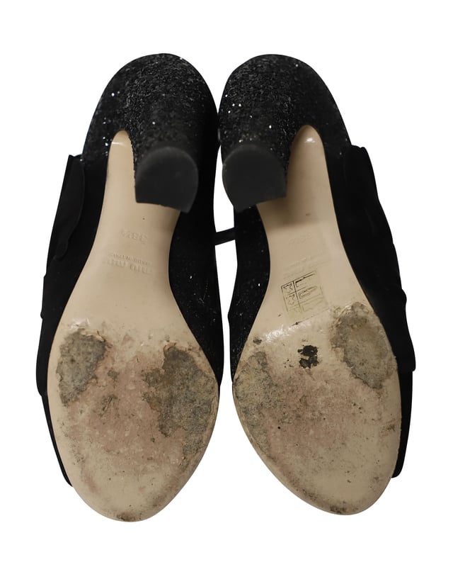 VINTAGE, UVP WIE NEU  
Diese schwarzen Peep-Toe-Stiefeletten von Miu Miu sind aus Wildleder gefertigt und mit Glitter überzogen, um deinen Stil gezielt zu heben. Sie sind mit Reißverschlüssen, Leder-Innensohlen ausgestattet und der Absatz misst 115 mm. Der Wildlederbereich der Schuhe ist so gestaltet, dass er wie ein Band aussieht, was einen zusätzlichen femininen Akzent setzt.

Miu Miu 115mm Glitter-Stiefeletten aus schwarzem Wildleder  
Zustand: Gut  
Nutzungsspuren: Starke Abnutzung an den Sohlen  
Material: Wildleder/Leder  
Größe: 38.5/US8.5  
Absatzhöhe: 115 cm  
SKU: 124358