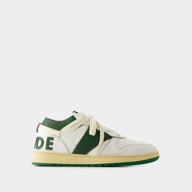 Presentamos las zapatillas Rhecess de Rhude, donde la frescura urbana se une a la comodidad contemporánea. Estas zapatillas fusionan a la perfección un diseño moderno con un guiño al estilo streetwear, mostrando una silueta única perfecta para ir a la moda statement. Para elevar tu look con estas zapatillas statement, considéralas la base de un conjunto moderno de inspiración callejera. Combínalas con unos vaqueros desgastados, una sudadera con capucha de estampado gráfico y unas gafas de sol atrevidas para conseguir un look vanguardista sin esfuerzo, perfecto para un día con amigos o una noche informal en la ciudad. Rhude Las zapatillas Rhecess de brand ejemplifican el compromiso de la marca con la calidad y la moda, ofreciéndote una opción de calzado distintiva y versátil que combina sin esfuerzo el encanto moderno con el estilo urbano. Sal con confianza, mostrando tu sensibilidad única por la moda y tu estilo de entrenador contemporáneo. Colores: blanco - blanco/verde oscuro. Material principal: piel de ternero lisa. Material de la suela: caucho. Material del forro: algodón. Cierre: cordones en la parte superior. Forma de la punta: almendra. Ajuste: fiel a la talla - Talla: