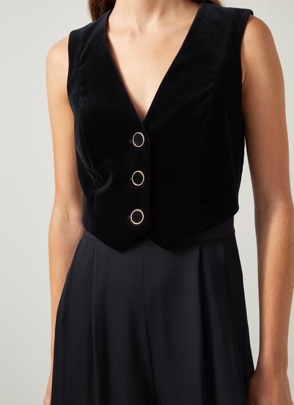 Be the center of attention with the Carine waistcoat culotte jumpsuit, ideal for evening events. In sleek black, this cotton blend jumpsuit boasts a v-neck, sleeveless design, mixed media details, and convenient pockets with a back zip. Combine it with statement heels and a clutch for an effortlessly stylish appearance.