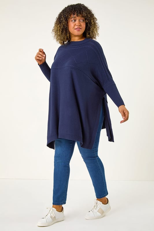 Curve High Neck Cable Knit Poncho from Roman. Wrap up warm in our trendy Curve cable knit poncho, an Autumn Winter must-have to your collection. Featuring a cosy high ribbed neckline, this stylish knit boasts a cable knit yoke detail for added flair. The full length sleeves give a modern touch, while the ribbed hem provides a flattering fit. Pair with jeans and trainers for an effortless stylish look that will keep you warm all season long!