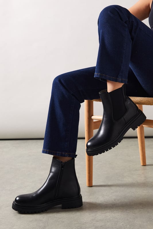 Chunky Chelsea ankle boot design
        Faux suede upper for a soft, luxurious feel
        Elastic side panels for easy slip-on
        Sturdy cleated sole for enhanced grip
        Low heel height between 2.5 and 4.5cm for comfortable wear
    
    The Melba Chunky Chelsea Ankle Boot from Oasis is a versatile staple that will carry you through the seasons with ease. These boots strike the perfect balance between style and practicality, featuring a classic Chelsea boot silhouette with a modern twist. The chunky cleated sole adds an edgy element to your look while providing excellent traction for various terrains. Pair these boots with your favourite skinny jeans and an oversized jumper for a cosy weekend brunch, or style them with a flowy midi dress and leather jacket for a night out with friends. The low heel ensures all-day comfort, making these boots ideal for city exploring or casual gatherings. Their timeless design means they'll complement a range of outfits, from relaxed daywear to smart-casual ensembles, making them a go-to choice for the fashion-conscious woman who values both style and comfort.