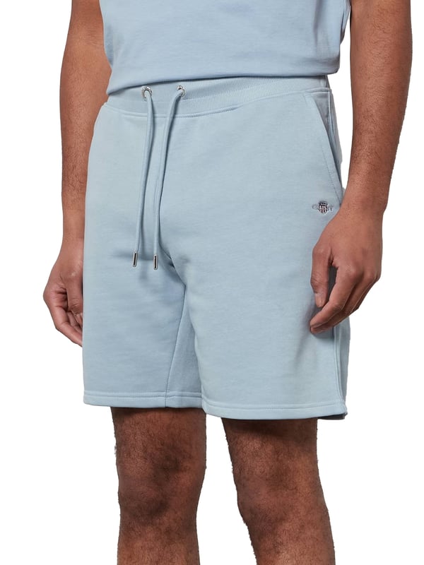 These classic sweat shorts are crafted from a soft cotton blend and tailored for a regular fit. Featuring a ribbed waistband for enhanced comfort, the design includes two front pockets, a single back pocket, and a drawstring waist. Completing the look, the shorts are adorned with a small-scale shield graphic embroidered on the left leg.