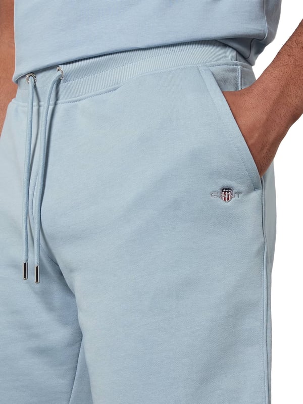These classic sweat shorts are crafted from a soft cotton blend and tailored for a regular fit. Featuring a ribbed waistband for enhanced comfort, the design includes two front pockets, a single back pocket, and a drawstring waist. Completing the look, the shorts are adorned with a small-scale shield graphic embroidered on the left leg.