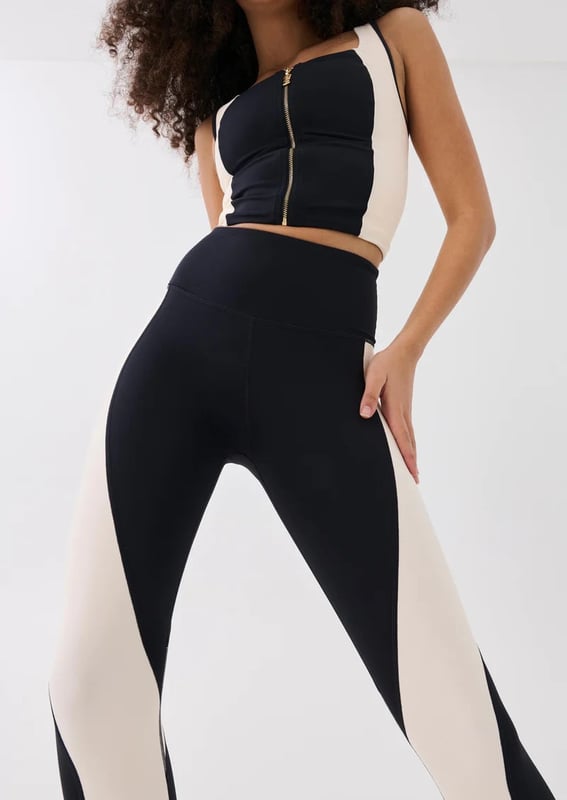 A high-rise full length legging cut in a soft compressive matte blend of recycled nylon and elastane. With built in waistband support, this style is ideal for low impact training and your street-sport wardrobe. A contrast beige curved panel detailing throughout and a P.E Nation silicon badge at the ankle for a minimal finish.
