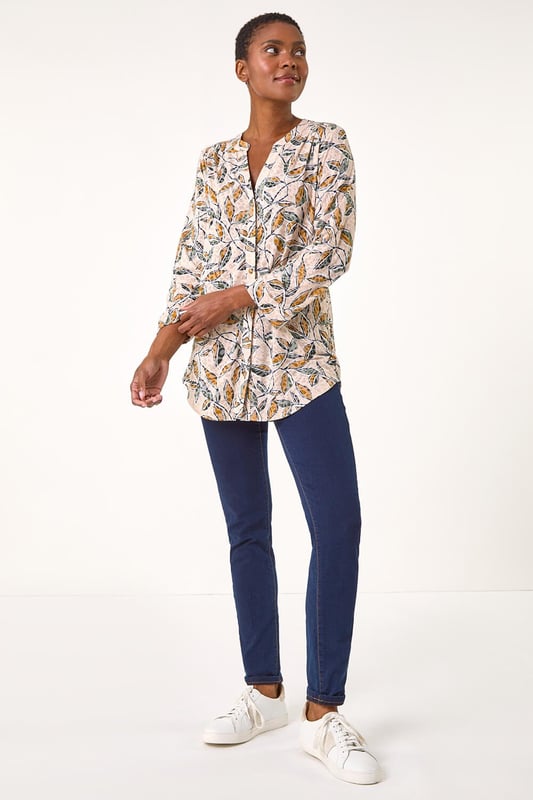Button Detail Leaf Print Blouse from Roman. Stand out this Autumn in this charming leaf print blouse. Featuring a striking all-over leaf design, this blouse comes complete with a sophisticated button-through centre front for easy wear. The addition of tabs on the sleeves adds a touch of casual chic to this statement piece. Pair with your favourite jeans and trainers for a stylish and trendy look that will take you from day to night effortlessly.
