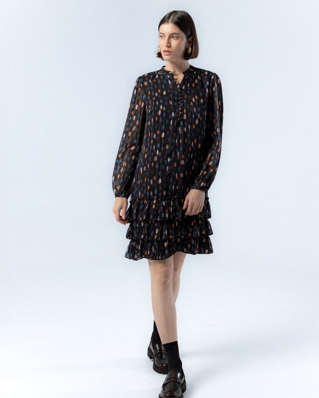 El vestido de lunares Alejandra, con su encantador estampado de lunares en tonos cálidos sobre fondo oscuro, te hará sentir la magia del otoño. Su diseño elegante y favorecedor es ideal para cualquier evento, añadiendo un toque de sofisticación y alegría a tu look.
 
 
 
 Vestido corto. 
 
 Abertura en escote con cierre de botones hasta la cintura. 
 
 Botones con aplique de piedras a mano. 
 
 Manga larga con puño elástico. 
 
 Bajo de tres volantes. 
 
 Tejido viscosa. 
 
 Estampado lunares.