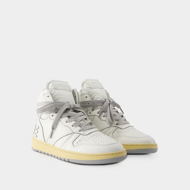 Presentamos las zapatillas Rhecess de Rhude, donde la frescura urbana se une a la comodidad contemporánea. Estas zapatillas fusionan a la perfección un diseño moderno con un guiño al estilo streetwear, mostrando una silueta única perfecta para ir a la moda statement. Para elevar tu look con estas zapatillas statement, considéralas la base de un conjunto moderno de inspiración callejera. Combínalas con unos vaqueros desgastados, una sudadera con capucha de estampado gráfico y unas gafas de sol atrevidas para conseguir un look vanguardista sin esfuerzo, perfecto para un día con amigos o una noche informal en la ciudad. Rhude Las zapatillas Rhecess de brand ejemplifican el compromiso de la marca con la calidad y la moda, ofreciéndote una opción de calzado distintiva y versátil que combina sin esfuerzo el encanto moderno con el estilo urbano. Sal con confianza, mostrando tu sensibilidad única por la moda y tu estilo de entrenador contemporáneo. Colores: Blanco - Blanco/Blanco. Material principal: piel de ternero lisa. Material de la suela: caucho. Material del forro: algodón. Cierre: cordones en la parte superior. Forma de la punta: almendra. Ajuste: fiel a la talla - Talla: