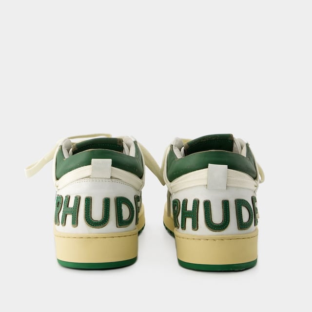 Presentamos las zapatillas Rhecess de Rhude, donde la frescura urbana se une a la comodidad contemporánea. Estas zapatillas fusionan a la perfección un diseño moderno con un guiño al estilo streetwear, mostrando una silueta única perfecta para ir a la moda statement. Para elevar tu look con estas zapatillas statement, considéralas la base de un conjunto moderno de inspiración callejera. Combínalas con unos vaqueros desgastados, una sudadera con capucha de estampado gráfico y unas gafas de sol atrevidas para conseguir un look vanguardista sin esfuerzo, perfecto para un día con amigos o una noche informal en la ciudad. Rhude Las zapatillas Rhecess de brand ejemplifican el compromiso de la marca con la calidad y la moda, ofreciéndote una opción de calzado distintiva y versátil que combina sin esfuerzo el encanto moderno con el estilo urbano. Sal con confianza, mostrando tu sensibilidad única por la moda y tu estilo de entrenador contemporáneo. Colores: blanco - blanco/verde oscuro. Material principal: piel de ternero lisa. Material de la suela: caucho. Material del forro: algodón. Cierre: cordones en la parte superior. Forma de la punta: almendra. Ajuste: fiel a la talla - Talla: