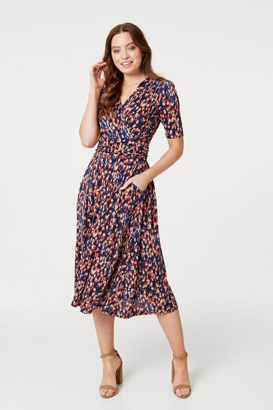 Add a comfortable jersey dress to your wardrobe with this printed midi. It has a v-neck with a faux wrap front, 1/2 sleeves, a flattering ruched waist and a straight midi length skirt. Pair with heels or boots for a go-to style to wear during transitional seasons.