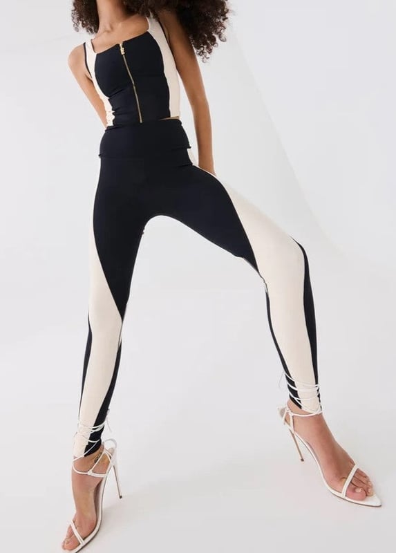 A high-rise full length legging cut in a soft compressive matte blend of recycled nylon and elastane. With built in waistband support, this style is ideal for low impact training and your street-sport wardrobe. A contrast beige curved panel detailing throughout and a P.E Nation silicon badge at the ankle for a minimal finish.