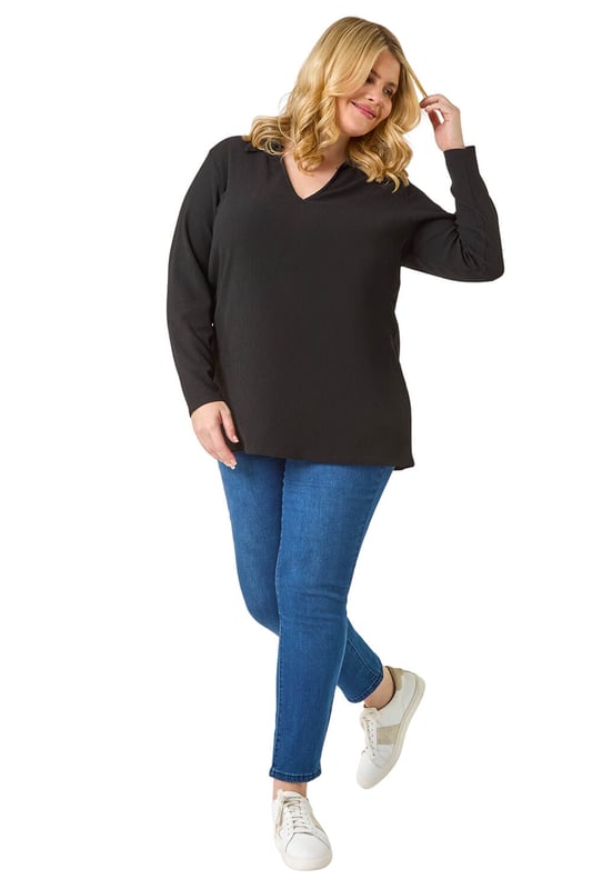 Curve Stretch V-Neck Collared Top from Roman. Elevate your casual style with this V-Neck jersey top, perfect for the Autumn/Winter season. Crafted from a textured jersey fabric, this top features a classic V-Neckline with a collar detail and comfortable long sleeves. The below hip length offers a flattering silhouette that pairs effortlessly with the matching trousers for a coordinated look. Complete your outfit with boots and a jacket for a chic and cozy ensemble.