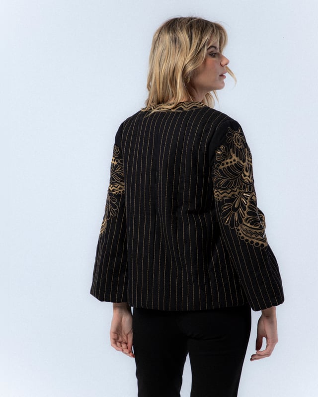 La Chaqueta Diana es una pieza clave para tu armario de otoño. Con su elegante diseño bordado y corte holgado, esta chaqueta ofrece un estilo sofisticado y moderno. Combínala con pantalones oscuros y tacones para un look chic y profesional.
 
 
 
 Chaqueta acolchada con cuello redondo.
 
 Manga larga.
 
 Bordado a máquina y a mano en delantero, espalda y mangas.