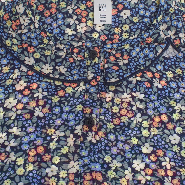Vestido camisero de niña con un encantador estampado floral, ideal para un look fresco y primaveral. 

Confeccionado en tejido ligero, este vestido presenta un diseño de botones en la parte frontal que resalta su estilo clásico y funcional. 

Su cuello redondo con detalles de ribete añade un toque delicado, mientras que las mangas largas le aportan versatilidad para cualquier ocasión. 

La cintura ligeramente fruncida crea un sutil efecto de vuelo en la parte inferior, dándole movimiento y elegancia. 

Perfecto para eventos especiales o para el día a día, este vestido combina comodidad y estilo en una prenda encantadora.
 Composición: 100% Viscosa
 Cuidados:
- Lavar a máquina máx. 30ºC.
- Utilizar colores similares en el lavado.
- Evitar el uso de blanqueadores.
- Secar a baja temperatura.
- Planchar a baja temperatura.
- No lavar en seco.