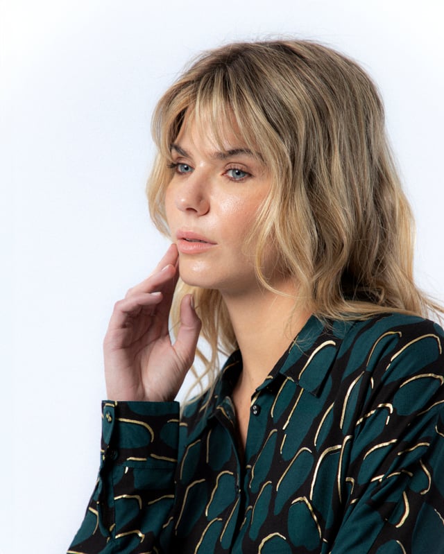 La camisa estampada Victoria te enamorará con su elegante color azul petróleo. Déjate envolver por el diseño sofisticado de la camisa Victoria.
 
 
 
 Blusa holgada con cuello solapa.
 
 Manga larga.
 
 Cierre frontal con botones.
 
 Detalle de tapete con botones en espalda.
 
 Tejido viscosa.
 
 Estampado Abstracto con detalles de foil dorado.