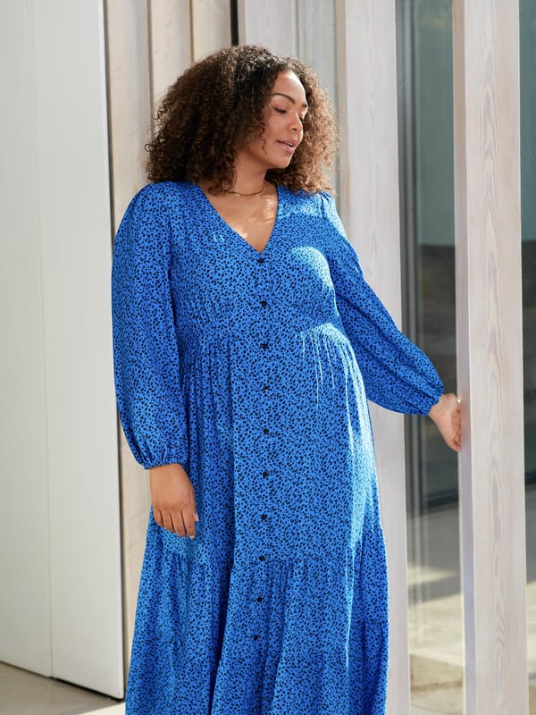 Printed all over with a beautiful blue ditsy print, this dress is cut from a soft woven fabric that moves beautifully. With a flattering tiered shape, it has a button-through front and an elasticated waistband to ensure the perfect fit. Voluminous sleeves add to its elegant silhouette, making it the perfect dress to elevate your everyday.