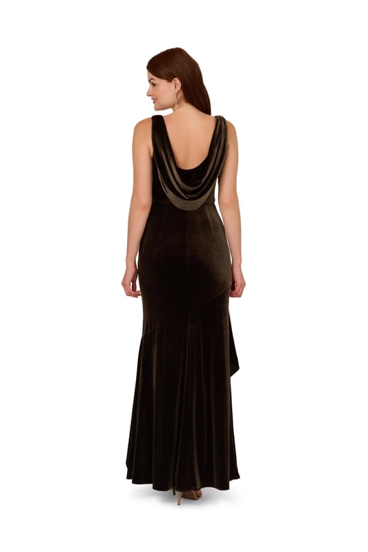 Elegant details elevate this velvet mermaid gown for the season. This formal dress features a sleeveless bodice, v-neckline, is fitted through the body, and contrasted by a mermaid skirt with a ruffled hem. Designed with a soft yet shining velvet fabric, this mermaid gown is elevated by a cowl back with a zipper closure at the centre back. Styled with nude high heels and a beaded clutch, this sleeveless velvet gown