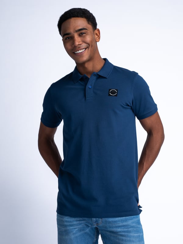 Unifarbenes Poloshirt mit offenem Kragen und Knopfleiste. Das Poloshirt ist mit einem im Brustbereich applizierten Petrol-Badge ausgeführt. In verschiedenen Farben erhältlich. Du schwankst zwischen zwei Größen? Nimm die größere Größe! Kurzarm-PoloshirtUnifarbenOffener KragenKnopfverschlussPetrol-Logo95 % Baumwolle, 5 % Elasthan