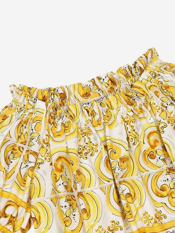 Dolce & Gabbana utilise new technological properties to create captivating aesthetics. This girls blouse is a part of the FW24/25 Girl‚  Collection. Depicted in Majolica, a symbol of Italian craftsmanship, it comes in lemon yellow, brightened up by pure white, taking inspiration from Sicilian pottery. Envisioned in cotton poplin with all-over yellow majolica print via a cropped fit and short puff sleeves, showcasing elasticated cuffs.  Made in Italy Boat Neck With Dropped Shoulders Stretch Hem Placed Print Due to "Handmade" Aspect 100% Cotton