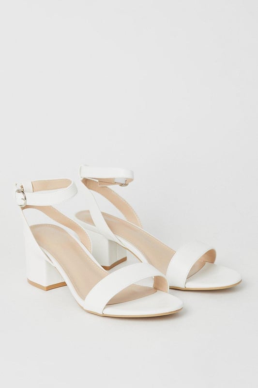 Wide fit design offers a comfortable and accommodating fit
Barely-there strappy silhouette with minimalist appeal
Mid block heel provides a modest lift and walkable height
Faux leather upper exudes a look and feel
Ankle strap with buckle closure ensures a secure fit

These versatile sandals are perfect for casual daytime outings or relaxed evening affairs. Pair them with a flowy midi dress or cropped trousers for a chic, on-trend look that transitions seamlessly from brunch with friends to an evening baby shower. The neutral hue complements a variety of ensembles, allowing you to showcase your personal style effortlessly.