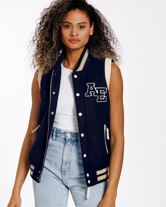 Een varsity gilet van hoge kwaliteit. Een moderne klassieker die altijd in stijl blijft. De jas is gemaakt van schapenwol. Aan beide zijden zitten ritszakken. De ritssluiting aan de voorkant van het jack kan worden gesloten met drukknopen.