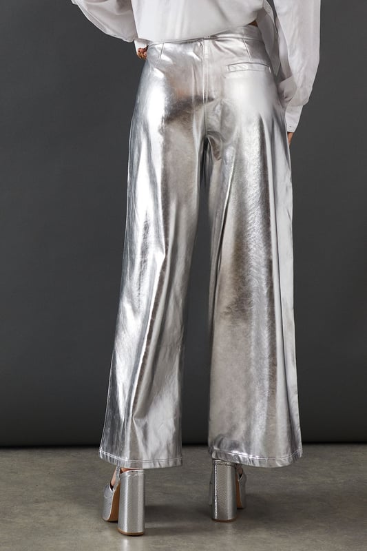 Eye-catching metallic finish for a bold statement
        Wide leg silhouette for a comfortable and trendy fit
        High-waisted design accentuates the waistline
        Front zip and button fastening for a secure fit
        Versatile style suitable for various occasions
    
    Make a dazzling entrance with these striking metallic wide leg jeans from Warehouse. Perfect for those who dare to stand out, these trousers combine comfort with high-impact style. The wide leg cut offers freedom of movement while creating a fashionable silhouette. For a night out on the town, pair these show-stopping trousers with a crisp white shirt, leaving it partially unbuttoned for a relaxed yet chic look. Add some platform sandals to elongate your legs and complete the ensemble with statement earrings. Whether you're hitting the dance floor or enjoying drinks with friends, these jeans will ensure you're the centre of attention. Their versatility also allows for more casual styling - try pairing with a simple black tee and trainers for an effortlessly cool daytime look that transitions seamlessly into evening wear.