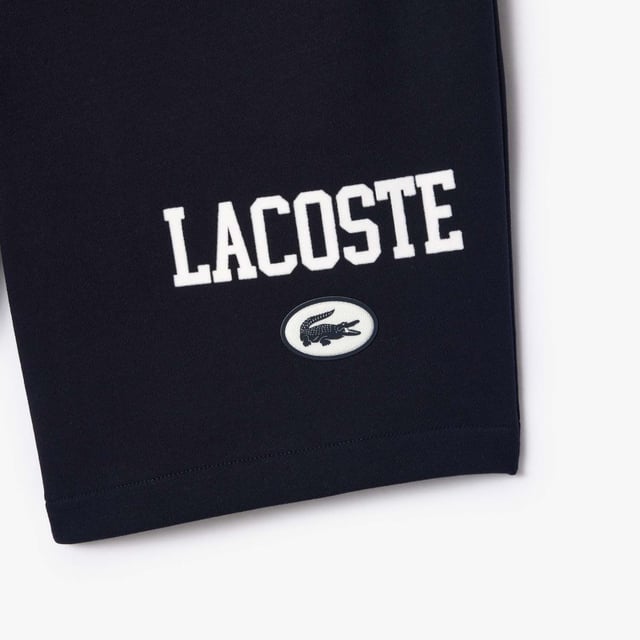 Own the french fashion sport The Joggers tracksuits : Comfort shape Regular fit  regular ease on body  hip and leg Shorts in our classic French Terry Climbing style drawcords 5cm puffed badge with silicone crocodile sewn at bottom Lacoste wording in flock print.
