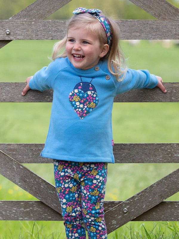 100% organic cotton | Proud to be certified to the Global Organic Textile Standard (GOTS) | Ladybird appliqué design featuring our flower patch print | OEKO-TEX Standard 100 (Product class I) appliqué backing | Cornflower blue | Brush back sweat fabric 3 ply (290-300 gsm) | Coconut button raglan sleeve opening (up to and including size 3 years) | Long sleeved | Round neck | Ribbed neckline and cuffs | Made in Turkey | Machine washable at 40 degrees, or at 30 degrees to be kinder to the planet