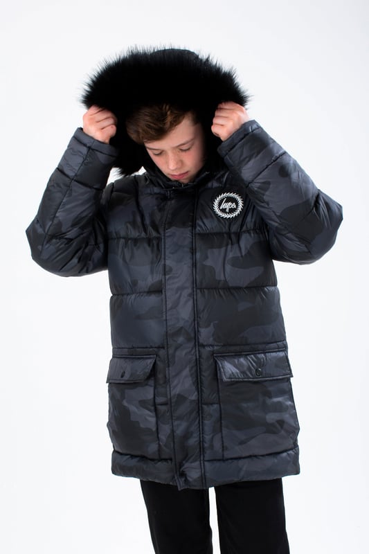 Imagine a completely versatile jacket that features both the parka and puffer style. Meet the HYPE. Kids Camo Explorer Jacket, part of the HYPE. 2022 Back to School collection. Designed in our standard unisex explorer parker shape, in our signature camo print in khaki and brown. Finished with an arm pocket and embossed justhype logo zip puller and a faux fur brown neutral hood trim. Machine wash at 30 degrees to keep in new condition.