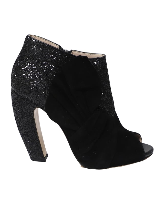VINTAGE, UVP WIE NEU  
Diese schwarzen Peep-Toe-Stiefeletten von Miu Miu sind aus Wildleder gefertigt und mit Glitter überzogen, um deinen Stil gezielt zu heben. Sie sind mit Reißverschlüssen, Leder-Innensohlen ausgestattet und der Absatz misst 115 mm. Der Wildlederbereich der Schuhe ist so gestaltet, dass er wie ein Band aussieht, was einen zusätzlichen femininen Akzent setzt.

Miu Miu 115mm Glitter-Stiefeletten aus schwarzem Wildleder  
Zustand: Gut  
Nutzungsspuren: Starke Abnutzung an den Sohlen  
Material: Wildleder/Leder  
Größe: 38.5/US8.5  
Absatzhöhe: 115 cm  
SKU: 124358