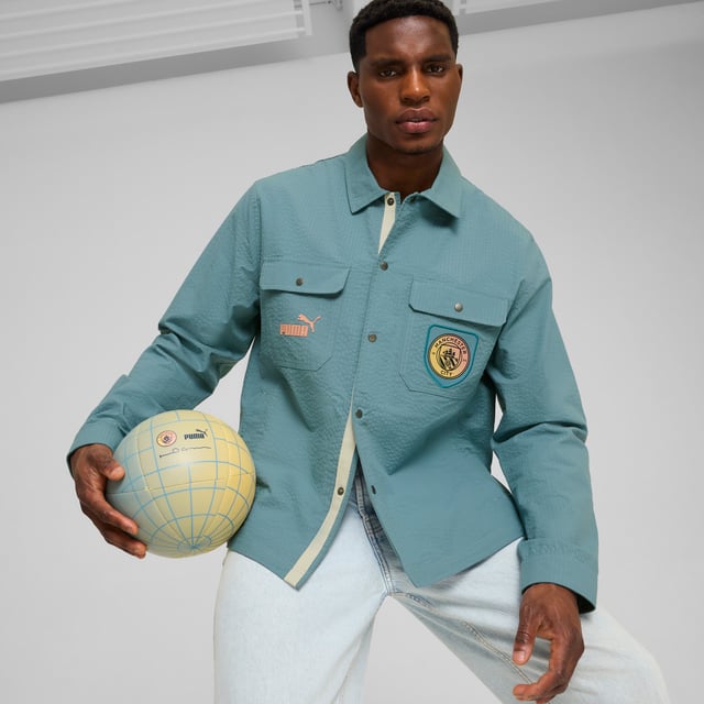 PRODUCT STORY: Marking 30 years of Definitely Maybe, its Definitely City. Co-designed by Noel Gallagher, a lifelong Man City fan, this relaxed fit overshirt pays homage to an album that defined an era. FEATURES & BENEFITS: Made with at least 20% recycled cotton. DETAILS: Relaxed fit; 165gsm, seersucker; Collar; Button placket; Long sleeves; Official team branding details. Our model is 186 cm tall and is wearing size M UK.