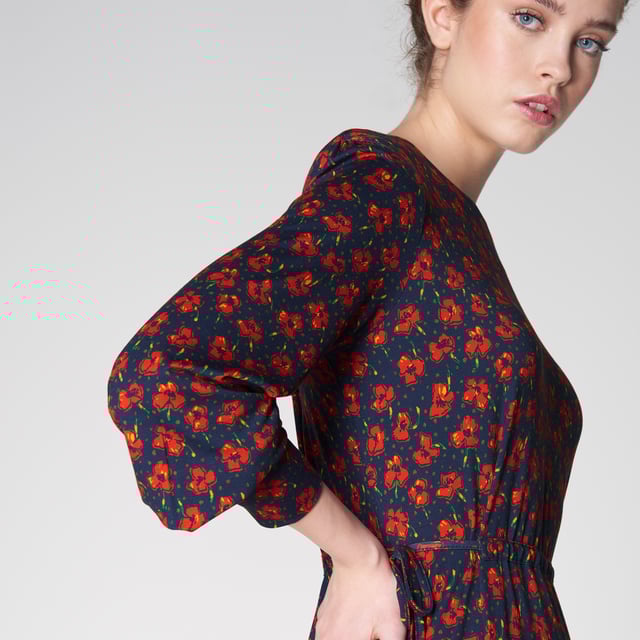 Jersey pieces are so comfortable, and our Carina dress takes on super-soft jersey in one of our favourite spring prints; the vintage archive poppy print. Crafted in Portugal from navy blue jersey with red poppies, it has a round neck, long sleeves with elegant cuffs, a drawstring waist and a knee-length skirt with a ruffled hemline. Wear it with a simple pair of trainers for a chic and casual everyday look.